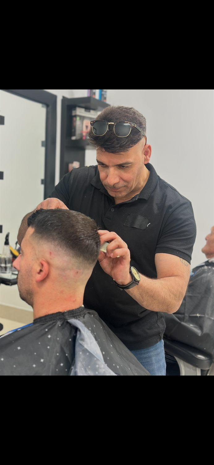 Barber blending a fade on a client